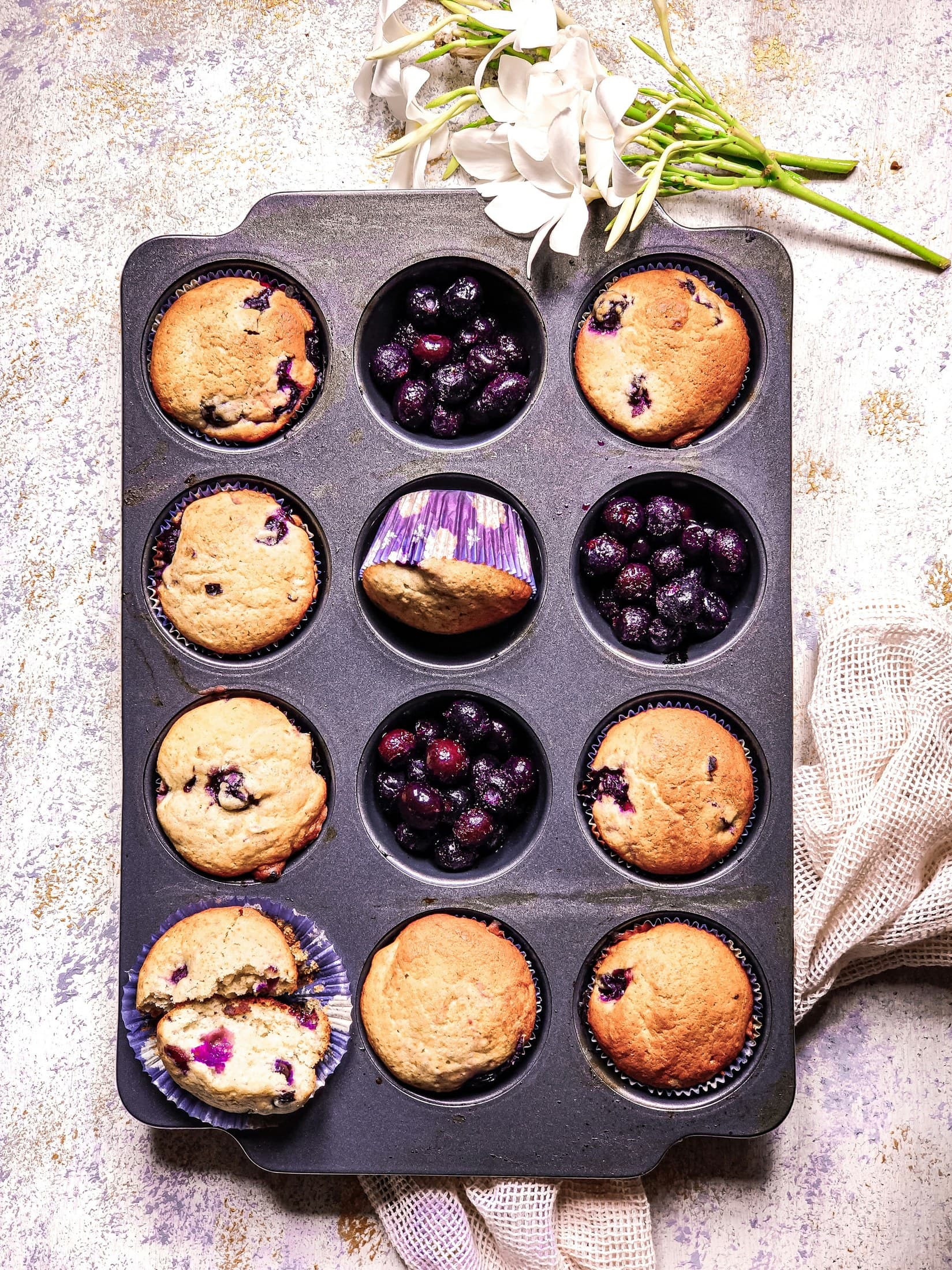 Blueberry muffins and blueberries arranged in a baking tray